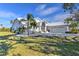 Stunning home features a well-manicured lawn, white metal roof, and three-car garage at 24344 Penhollow Ct, Punta Gorda, FL 33955
