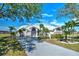 Beautiful home featuring a white metal roof, lush landscaping, and a long private driveway at 24344 Penhollow Ct, Punta Gorda, FL 33955
