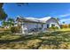 Well-maintained home exterior with a neutral color scheme, mature landscaping, and a metal roof at 24344 Penhollow Ct, Punta Gorda, FL 33955