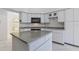 Kitchen featuring a center island, white cabinets, granite countertops and tile floors at 24344 Penhollow Ct, Punta Gorda, FL 33955