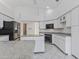Well-lit kitchen featuring white cabinets, granite counters, a black fridge, and tile flooring at 24344 Penhollow Ct, Punta Gorda, FL 33955