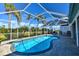 Sparkling pool surrounded by a screened enclosure, with patio seating, and serene tropical landscaping at 24344 Penhollow Ct, Punta Gorda, FL 33955