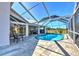 Wide view of screened pool and patio area with outdoor seating and dining at 24344 Penhollow Ct, Punta Gorda, FL 33955