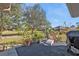 Cozy backyard patio seating area with lush green landscaping and mature trees at 25202 Chiclayo Ave, Punta Gorda, FL 33983