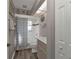 A compact bathroom with a shower-tub combo, a single sink vanity, and neutral walls with beach-themed decor at 25202 Chiclayo Ave, Punta Gorda, FL 33983
