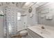 Bright bathroom with a tub-shower, single sink vanity, beach themed curtain, and decorative artwork at 25202 Chiclayo Ave, Punta Gorda, FL 33983