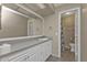 Well-lit bathroom with white cabinets, large mirror, and toilet at 26300 Rampart Blvd # 404, Punta Gorda, FL 33983