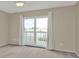 Bedroom with large sliding glass door, curtains, and water view at 26300 Rampart Blvd # 404, Punta Gorda, FL 33983