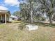 Lush backyard with mature trees, features a fire pit and hammock, perfect for relaxation and outdoor enjoyment at 2822 Logsdon St, North Port, FL 34287