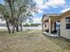 Expansive backyard featuring a covered patio with seating, mature trees, and a white fence for added privacy at 2822 Logsdon St, North Port, FL 34287