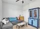 Cozy bedroom with a gray sofa, ceiling fan, and a blue armoire at 2822 Logsdon St, North Port, FL 34287