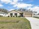 Charming single-story home with beige stucco, dark shutters, well-maintained landscaping, and an attached two-car garage at 2822 Logsdon St, North Port, FL 34287