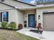 Inviting front porch with blue front door, accent plants, and a classic rocking chair at 2822 Logsdon St, North Port, FL 34287