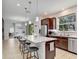 Kitchen features an island with bar stool seating, stainless appliances, and dark wood cabinetry at 2822 Logsdon St, North Port, FL 34287