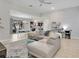 Open-concept living room with tile floors, modern furnishings, and seamless flow to the dining area and kitchen at 2822 Logsdon St, North Port, FL 34287