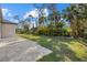 Lush green backyard with manicured lawn and landscaping, adjacent to stone patio at 3049 Seth Rd, North Port, FL 34288