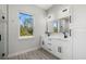Bright bathroom with a double vanity, framed mirror, and a view to the outside at 3049 Seth Rd, North Port, FL 34288