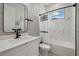 Bathroom features a single vanity with a framed mirror and shower and tub with marble wall tiles at 3049 Seth Rd, North Port, FL 34288