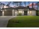 Charming single-story home featuring a two-car garage, manicured lawn, and modern design elements at 3049 Seth Rd, North Port, FL 34288