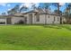 A sprawling green lawn surrounds this single-story home with a modern, minimalist architectural design at 3049 Seth Rd, North Port, FL 34288