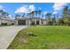 Exterior view of home featuring modern architecture, a spacious lawn, and a paved driveway at 3049 Seth Rd, North Port, FL 34288