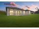 Beautiful home exterior featuring covered patio, manicured lawn at dusk at 3049 Seth Rd, North Port, FL 34288