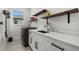 Well-organized laundry room with a modern washer, white cabinets, and floating shelves at 3049 Seth Rd, North Port, FL 34288