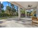 Spacious covered patio with stone flooring, ceiling fan, and grill, overlooking a lush backyard at 3049 Seth Rd, North Port, FL 34288
