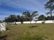 Expansive backyard featuring lush green grass, palm trees, fountain, and a white vinyl fence at 3289 Pellam Blvd, Port Charlotte, FL 33948