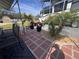 Beautiful brick patio with palm trees, flowers, and lawn at 3289 Pellam Blvd, Port Charlotte, FL 33948