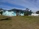 Charming, one-story home painted turquoise with manicured lawn and statue decorations at 3289 Pellam Blvd, Port Charlotte, FL 33948