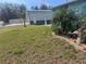 Landscaped front yard with palm trees and a decorative flamingo statue at 3289 Pellam Blvd, Port Charlotte, FL 33948