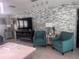 Stylish living room featuring turquoise accent chairs, stone wall, and modern decor at 3289 Pellam Blvd, Port Charlotte, FL 33948