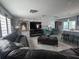 Bright living room featuring a modern brick accent wall and gray tile floors at 3289 Pellam Blvd, Port Charlotte, FL 33948