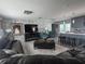 Open-concept living room with stylish stone accent wall and modern furnishings adjacent to modern kitchen at 3289 Pellam Blvd, Port Charlotte, FL 33948