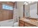 Bathroom with tiled walls, granite countertop, decorative window, and white bathtub at 3321 Tripoli Blvd, Punta Gorda, FL 33950