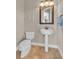 Bathroom with pedestal sink, large framed mirror, and tiled floors at 3321 Tripoli Blvd, Punta Gorda, FL 33950