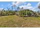 Spacious backyard featuring lush lawn, tropical landscaping, and perimeter fencing at 4504 Vaquero St, North Port, FL 34286