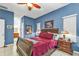 Stylish bedroom featuring a dark wooden sleigh bed, blue accent walls, and tile flooring at 4504 Vaquero St, North Port, FL 34286