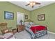 Charming bedroom with green walls featuring tile floors, a ceiling fan, and iron bed frame at 4504 Vaquero St, North Port, FL 34286