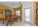Bright dining room with a wooden dining set, stylish lighting, and access to the front entrance at 4504 Vaquero St, North Port, FL 34286