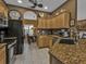 Well-lit kitchen features stainless appliances, granite counters, tile backsplash, and an eat-in dining area at 4504 Vaquero St, North Port, FL 34286