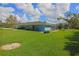 Spacious backyard with lush green lawn and partial view of the home's exterior at 5131 Appomattox Dr, North Port, FL 34287