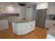 Bright kitchen featuring white cabinets, a stainless steel refrigerator, and a center island at 5131 Appomattox Dr, North Port, FL 34287