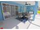 Covered lanai featuring tiled floor, dining table, ceiling fan and sliding glass doors leading to the interior at 5131 Appomattox Dr, North Port, FL 34287