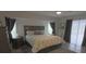Bright main bedroom features a ceiling fan, wood flooring, and a sliding glass door at 5131 Appomattox Dr, North Port, FL 34287