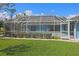 Rear view of property featuring a large screened in lanai and mature privacy landscaping at 5131 Appomattox Dr, North Port, FL 34287