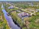 Aerial view of waterfront property with screened pool, lush landscaping, and canal access at 8230 Agate St, Port Charlotte, FL 33981