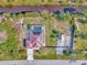 Aerial view of a property with a pool, red metal roof, solar panels, boat parking, and fenced-in yard at 8230 Agate St, Port Charlotte, FL 33981