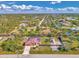 Aerial view of a home on a large, landscaped lot that includes a boat parking area and a red metal roof at 8230 Agate St, Port Charlotte, FL 33981